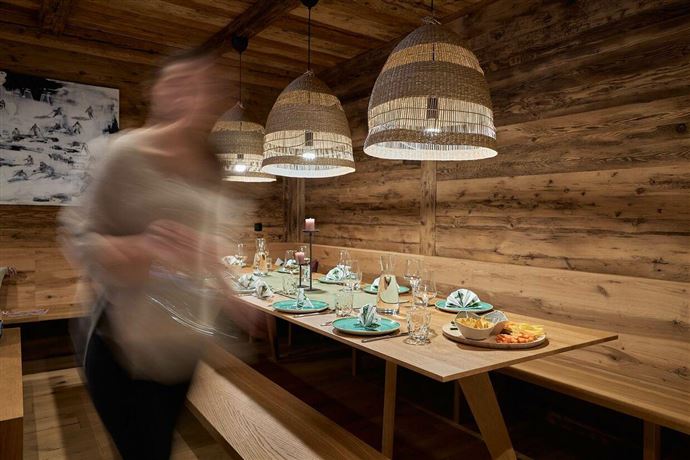An inviting dining area with wood decor and stylish lamps. The table is beautifully set, ready for a festive meal.
