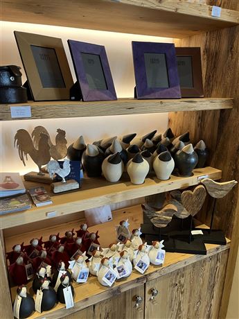 A wooden shelf with various decorative figures and picture frames. The objects are arranged in different colors and shapes.