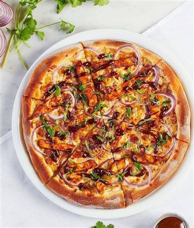 Eine leckere Pizza mit Hähnchen, roten Zwiebeln und frischen Kräutern. Der knusprige Rand ist mit einer würzigen Sauce verfeinert.