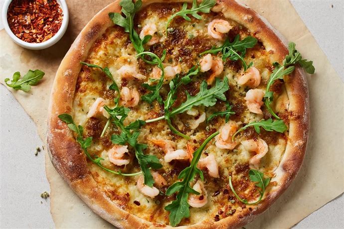 Eine köstliche Pizza mit Garnelen und Rucola. Die knusprige Kruste ist perfekt gebräunt und mit Gewürzen verfeinert.