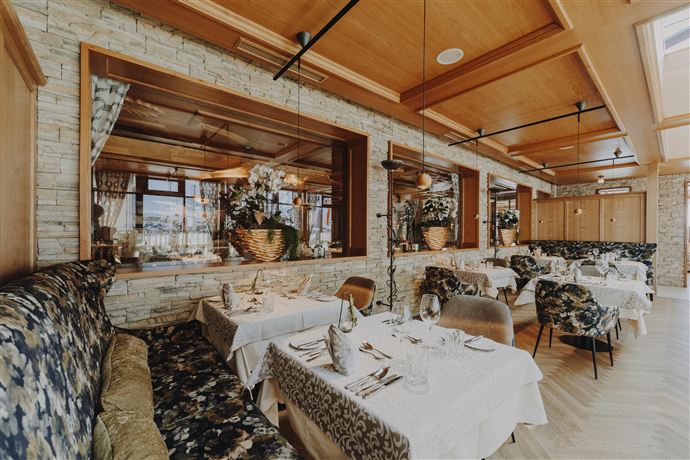 An elegant restaurant with beautifully set tables and stylish interior. The atmosphere is cozy and inviting.
