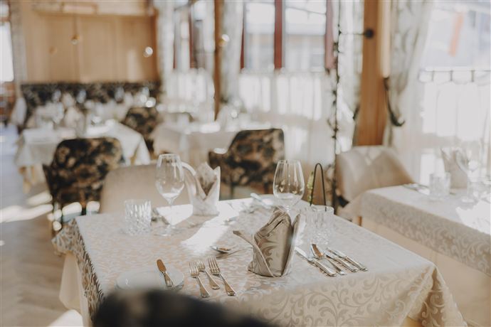 An elegant restaurant with tastefully set tables. Plenty of daylight streams through the windows, creating an inviting atmosphere.