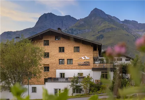 A charming wooden building with mountain views. The surroundings are green and invite relaxation.
