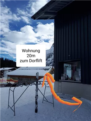 An apartment near a village lift, just 20 meters away. The surroundings are snow-covered with a clear sky.