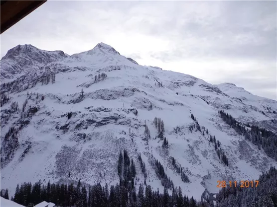 Eine beeindruckende Berglandschaft bedeckt mit Schnee. Die Wolken bieten einen grazilen Hintergrund für die majestätischen Gipfel.